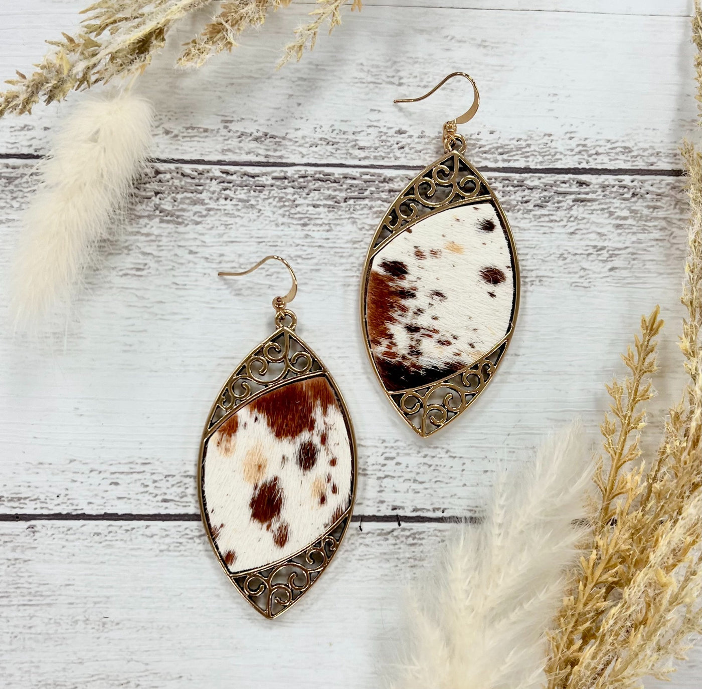 Cowhide Serenade: Gilded Gold Scroll Earrings with a Twist