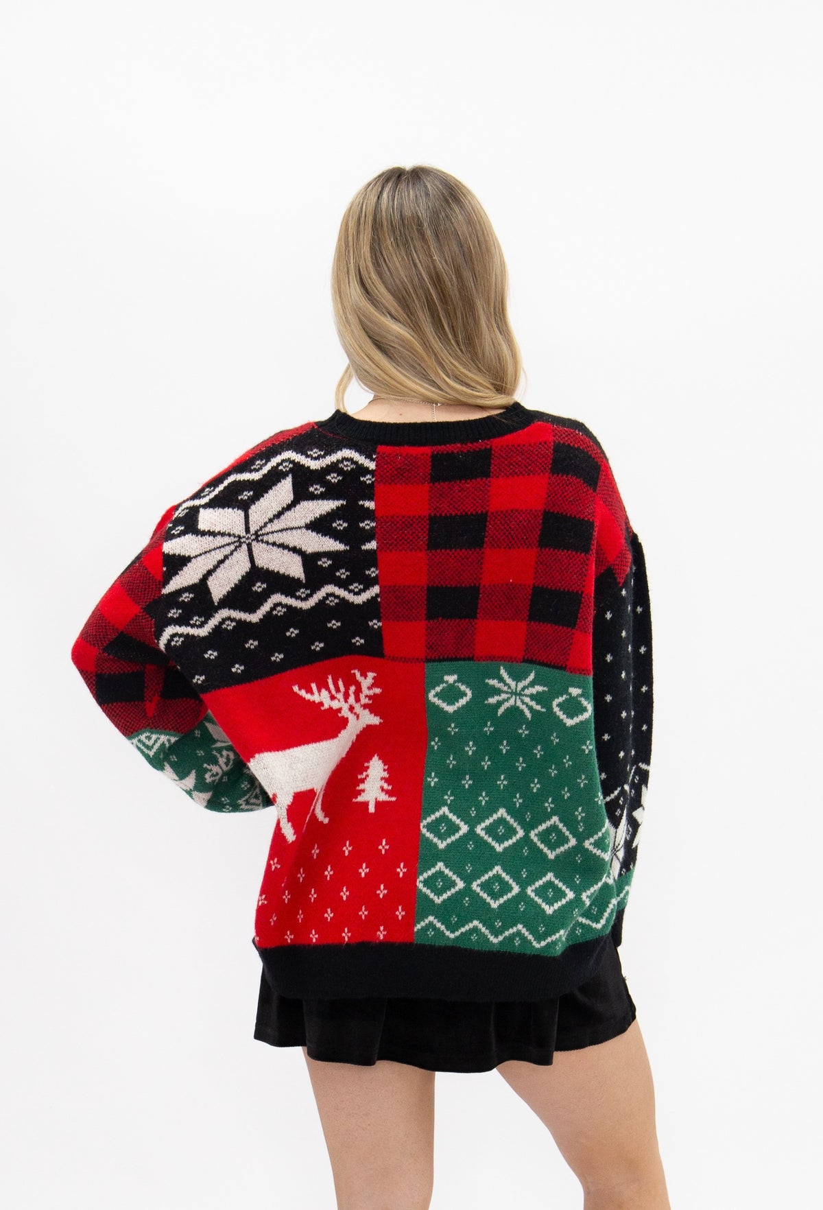 Patchwork holiday sweater with reindeer and snowflakes.