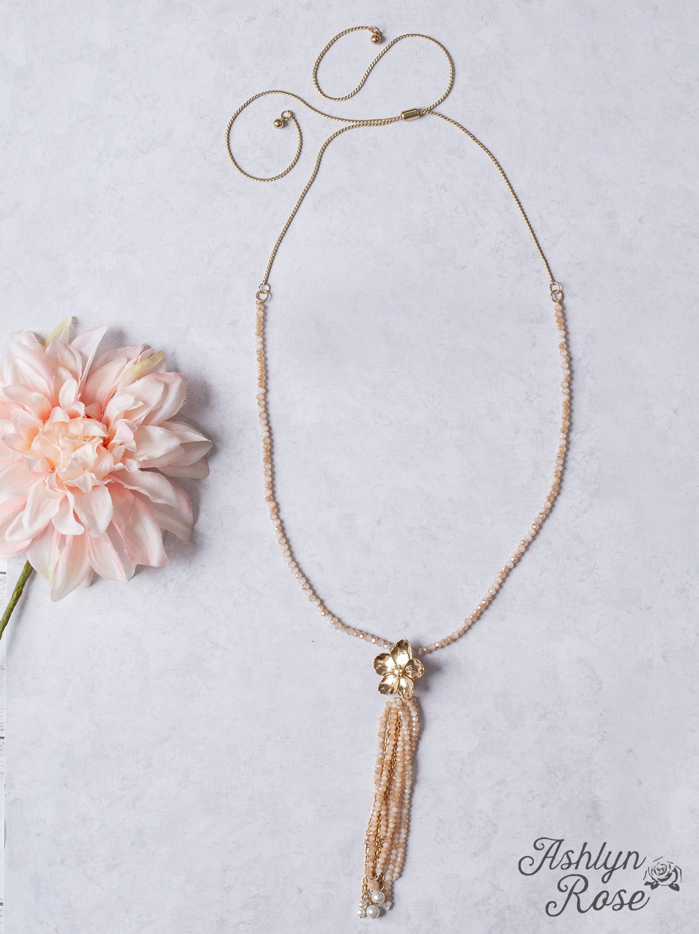 IMPRESS ME GOLD FLOWER TASSEL PENDANT ON A ROSY TAN CRYSTAL BEADED NECKLACE
